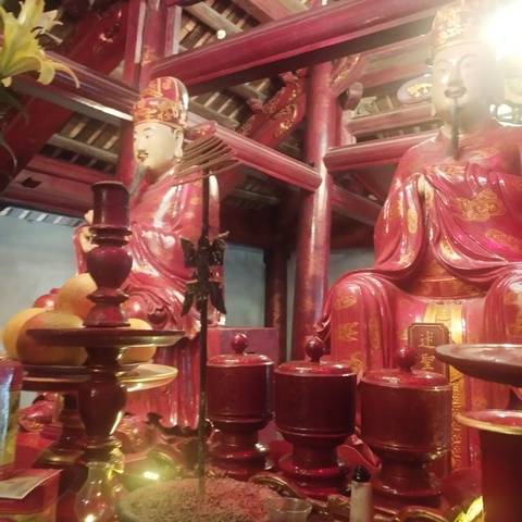 Interior of a temple with ornate red sculptures and traditional decor.