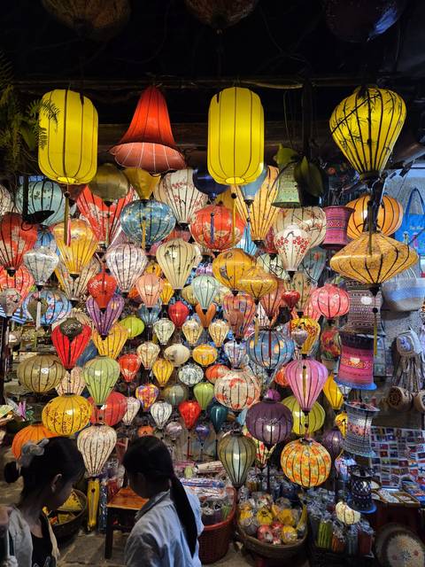 Colorful illuminated lanterns hanging in a market setting.
