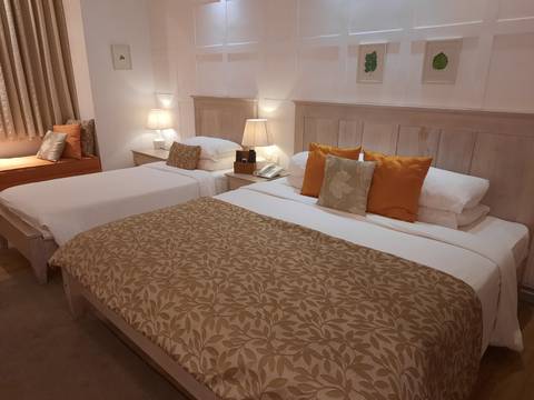      Hotel room with two beds neatly arranged with lamps and decor
  