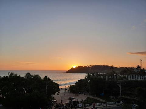       Sunset seen from the beach with a silhouette of the landscape
  