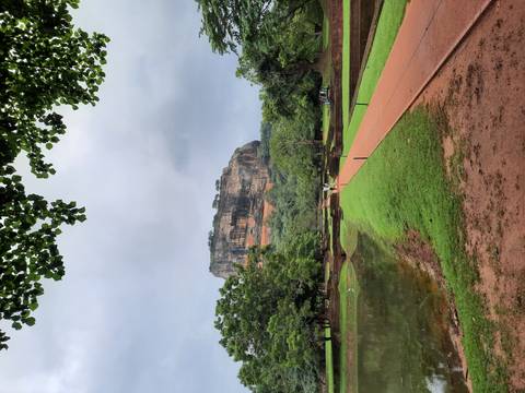       Iconic rock fortress surrounded by lush greenery after rain
  