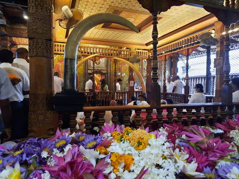 Interior of a temple with worshippers and flower offerings