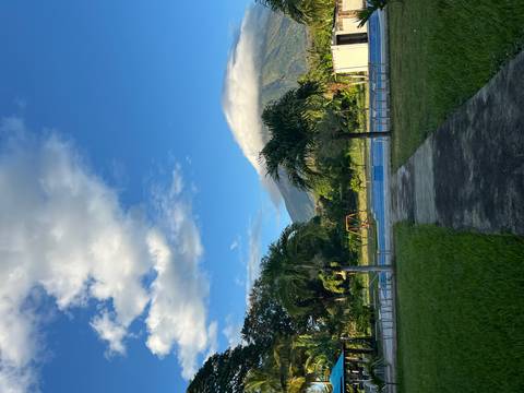       A path leading to a pool with mountains in the distance under a blue sky.
  