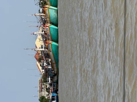 Boats docked along a river with clear skies.