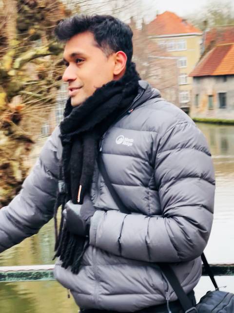 Close-up of a person's winter attire with a canal in the background.