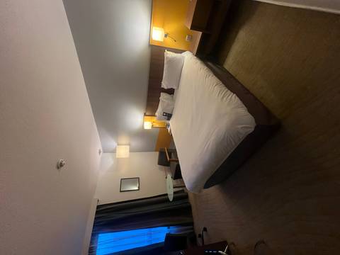 Hotel room with bed and night lamps.