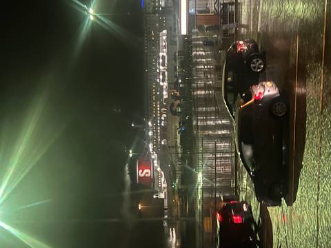Parking lot at night with a ferry and cars.