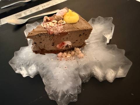       Dessert served on an ice plate, garnished with berries and chocolate.
  