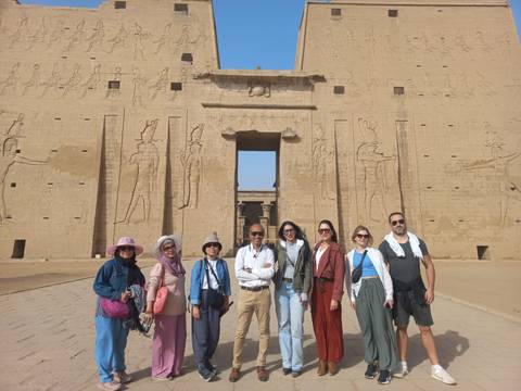 Large group posing in front of an ancient Egyptian temple entrance.