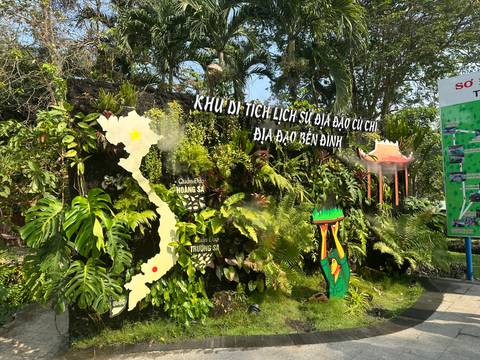 Historical site entrance with lush greenery and a map of Vietnam