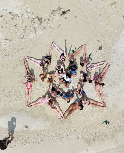 Large group lying on the sand forming a circular pattern