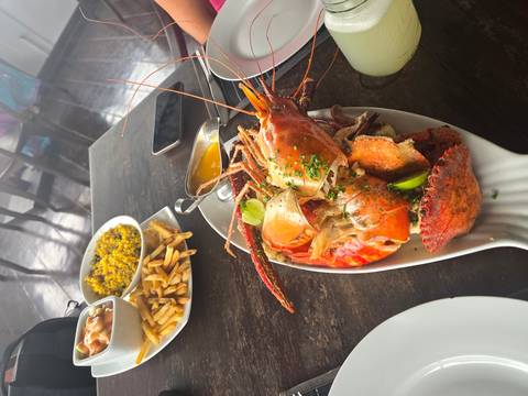 Lobster dish served with fries and sides on a table