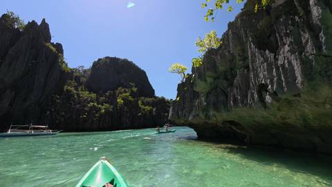       People kayaking through rock formations.
  