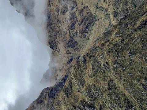       Mountainous landscape with mist and rugged terrain.
  