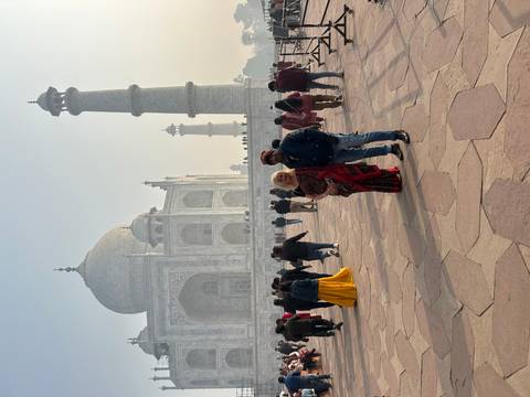 Two tourists posing in front of the Taj Mahal.