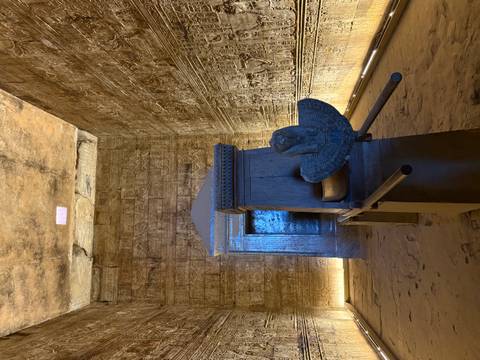       Interior of ancient Egyptian temple with hieroglyphics and artifacts.
  