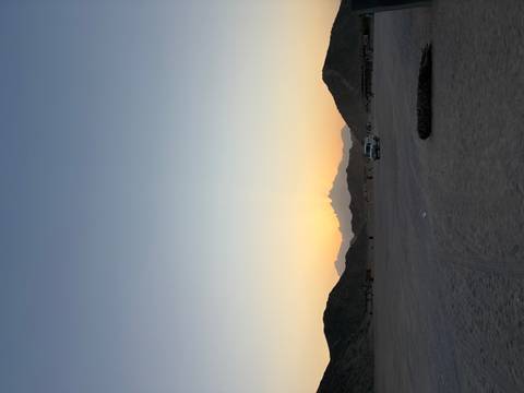 Desert landscape with sunset and distant mountains.