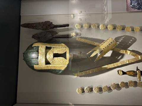       Antique helmet and artifacts displayed in a museum.
  