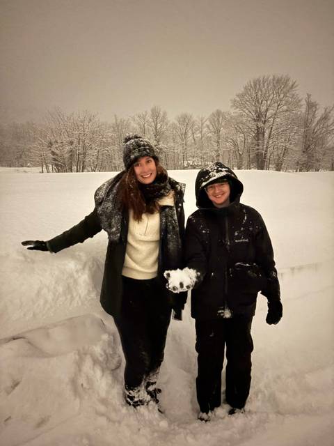 Smiling couple posing in snow-covered landscape.