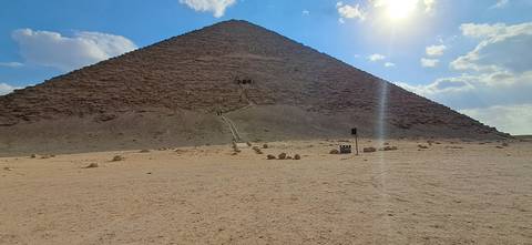       Desert pyramid under a bright sunlit sky.
  