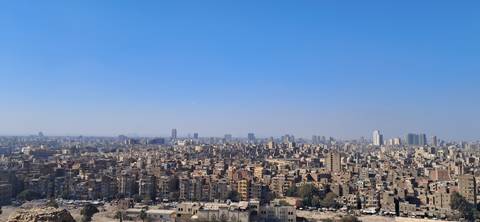       Panoramic view of a sprawling cityscape under a clear blue sky.
  