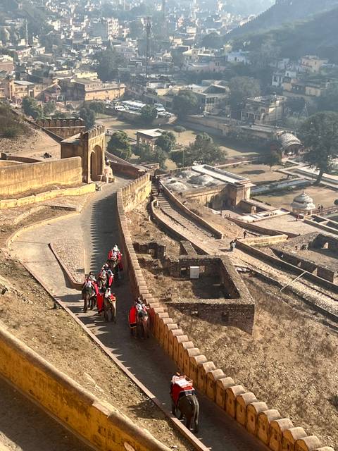 Elephants being guided along a path at a fort.