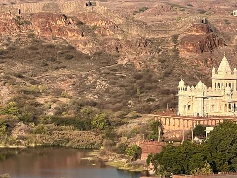 Palace overlooking rocky hills and a lake.