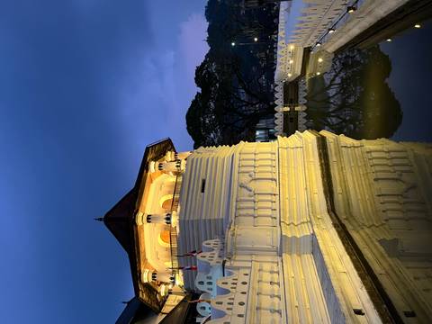 Illuminated temple by the water at dusk.