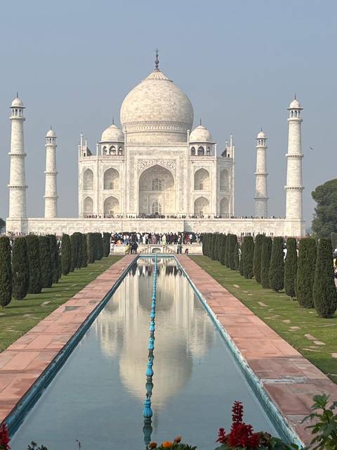       The Taj Mahal with many visitors and clear sky.
  