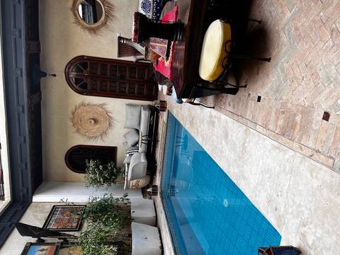       Cozy courtyard with a private pool, seating, and plant decoration, creating a charming atmosphere.
  