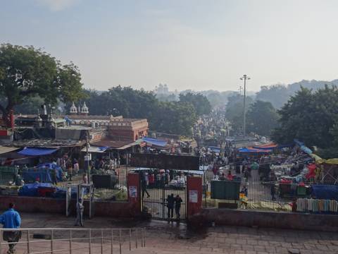       Busy morning market scene with hundreds of stalls, tarps and crowds stretching into the distance.
  