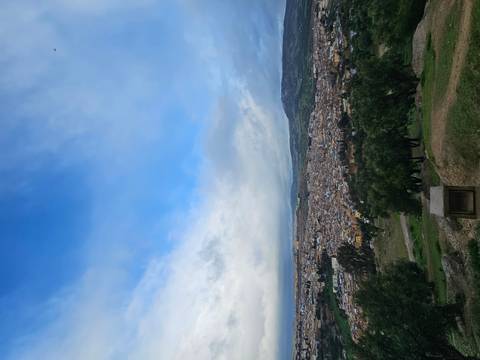       Elevated view of the sprawling city of Fes stretching beneath a bright blue sky.
  