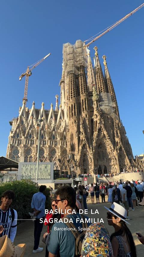       The ornate stone and spire-topped facade of the Sagrada Familia rising against a clear blue sky.
  