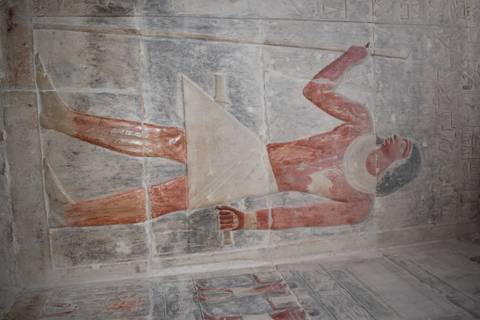       Ancient Egyptian relief carving of a noble figure inside a tomb.
  