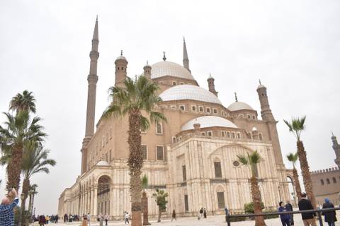       The grand Muhammad Ali Mosque with soaring minarets framed by palms.
  