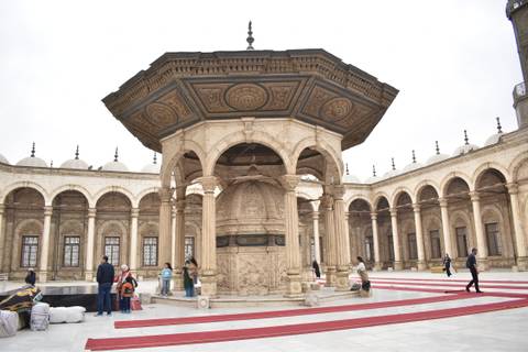       Ornate ablution fountain and arched colonnade inside the courtyard of Muhammad Ali Mosque.
  
