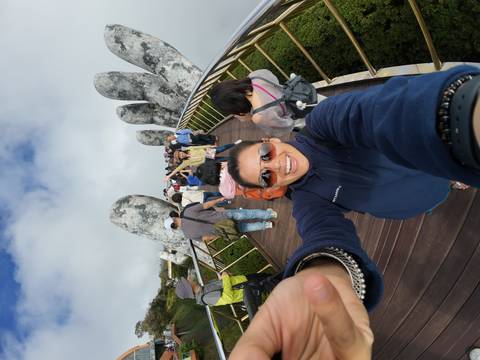       Selfie on the crowded Golden Bridge showing stone hands and happy tourists.
  