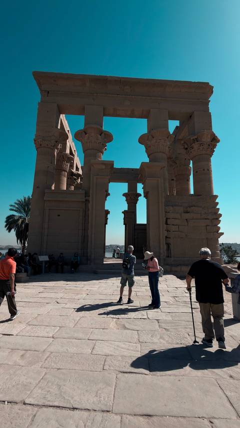       Visitors explore the columned gateway of an ancient riverside temple complex
  