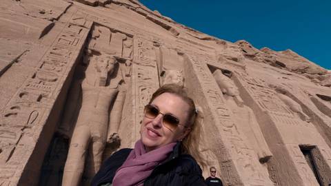       Traveler takes selfie in front of colossal statues and hieroglyphics at Abu Simbel
  