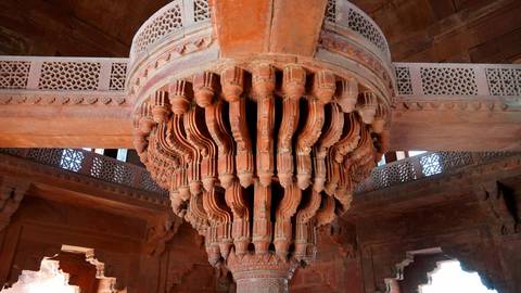       An intricately carved sandstone central column chandelier inside Fatehpur Sikri's Diwan-i-Khas.
  
