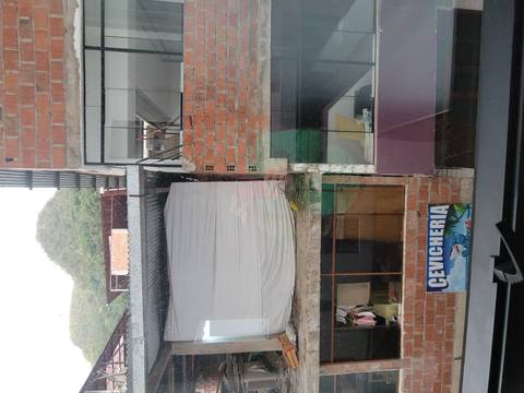      Urban view from window showing brick buildings and a cevicheria sign
  
