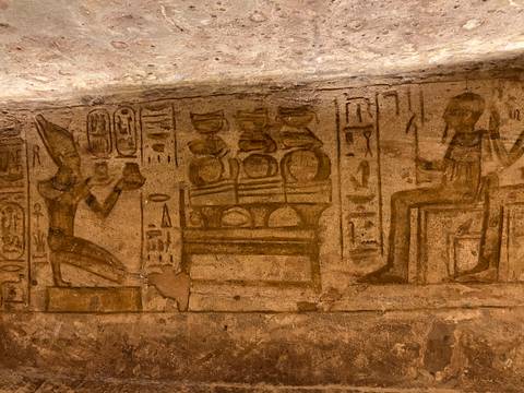       Detailed ancient Egyptian wall reliefs and hieroglyphs in warm interior lighting.
  