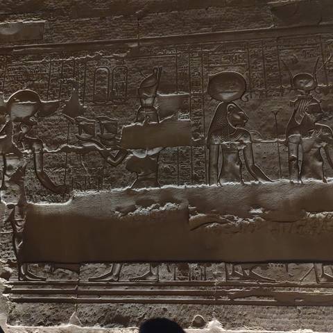       Detailed ancient Egyptian relief carvings of deities and hieroglyphs on a temple wall.
  