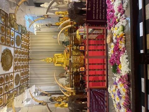       Interior of the Temple of the Tooth displaying golden Buddha statue and ivory tusks.
  