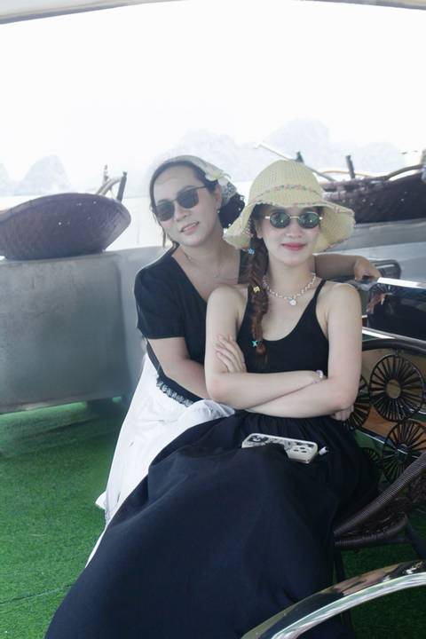       Two women in sun hats and sunglasses posing on the deck of a river cruise boat.
  
