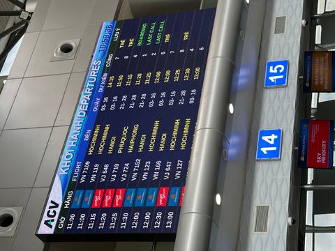       Electronic departures board inside an airport showing multiple flights to Ho Chi Minh City.
  
