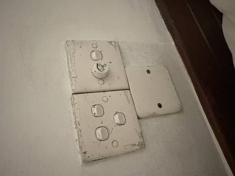       Worn and dirty light switches on a stained wall.
  