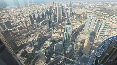       Sweeping aerial view of downtown Dubai’s skyscrapers and highways taken from a high observation deck.
  