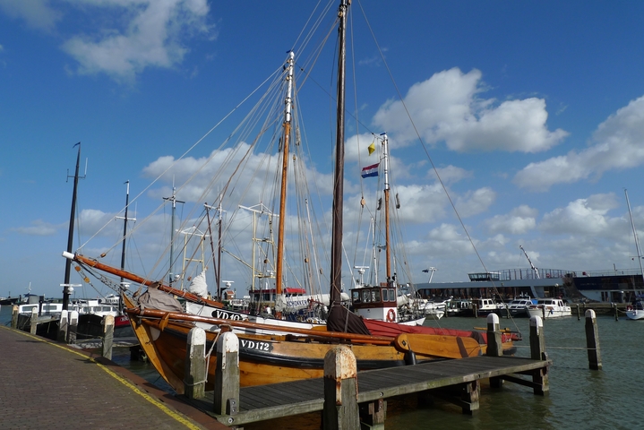 Boats docked in a harbor with clear sky.