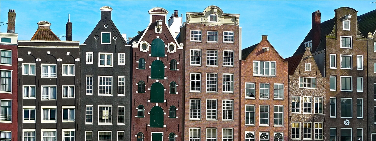 Traditional Dutch canal houses against a clear sky.